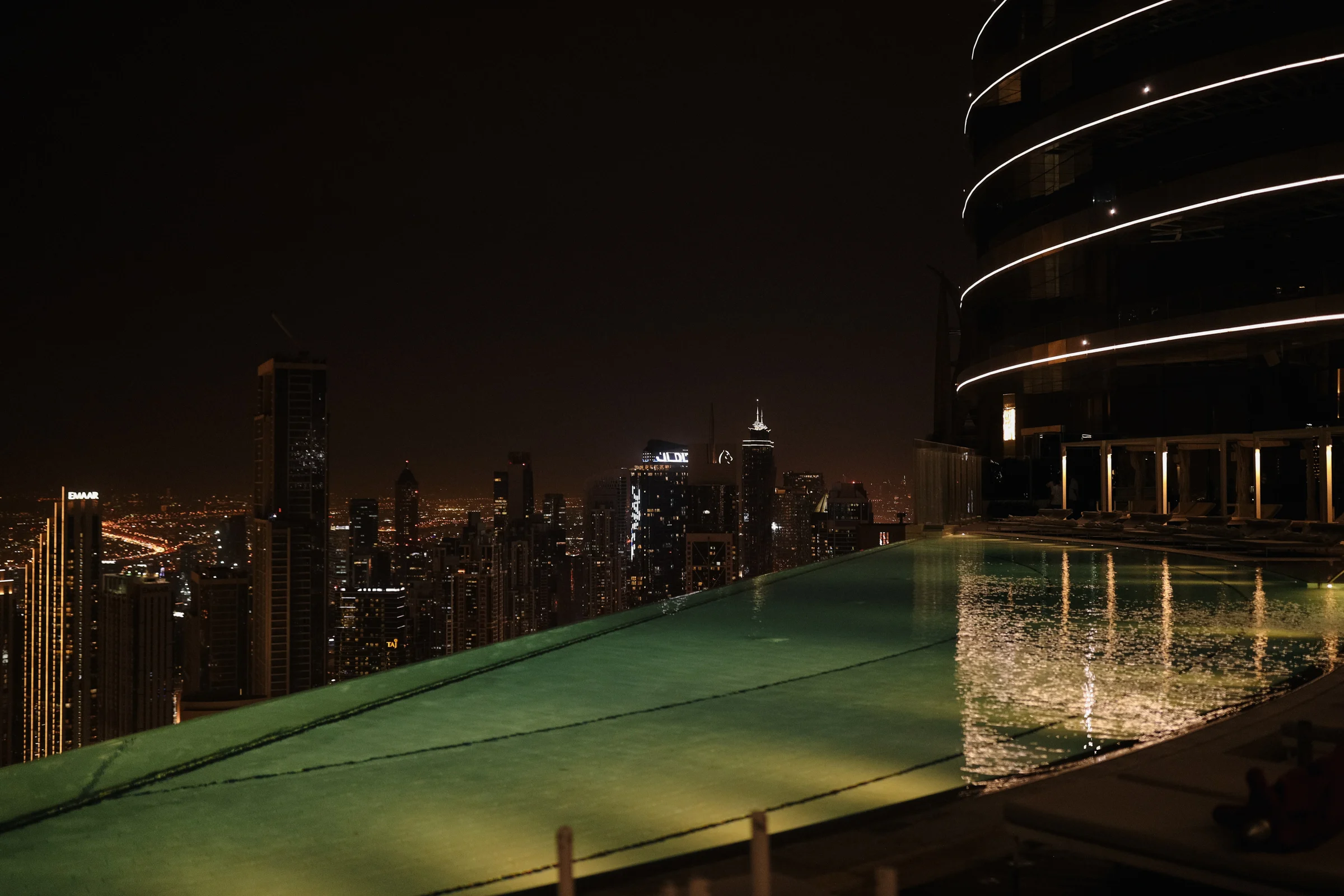 Rooftop pool with the Dubai skyline at night